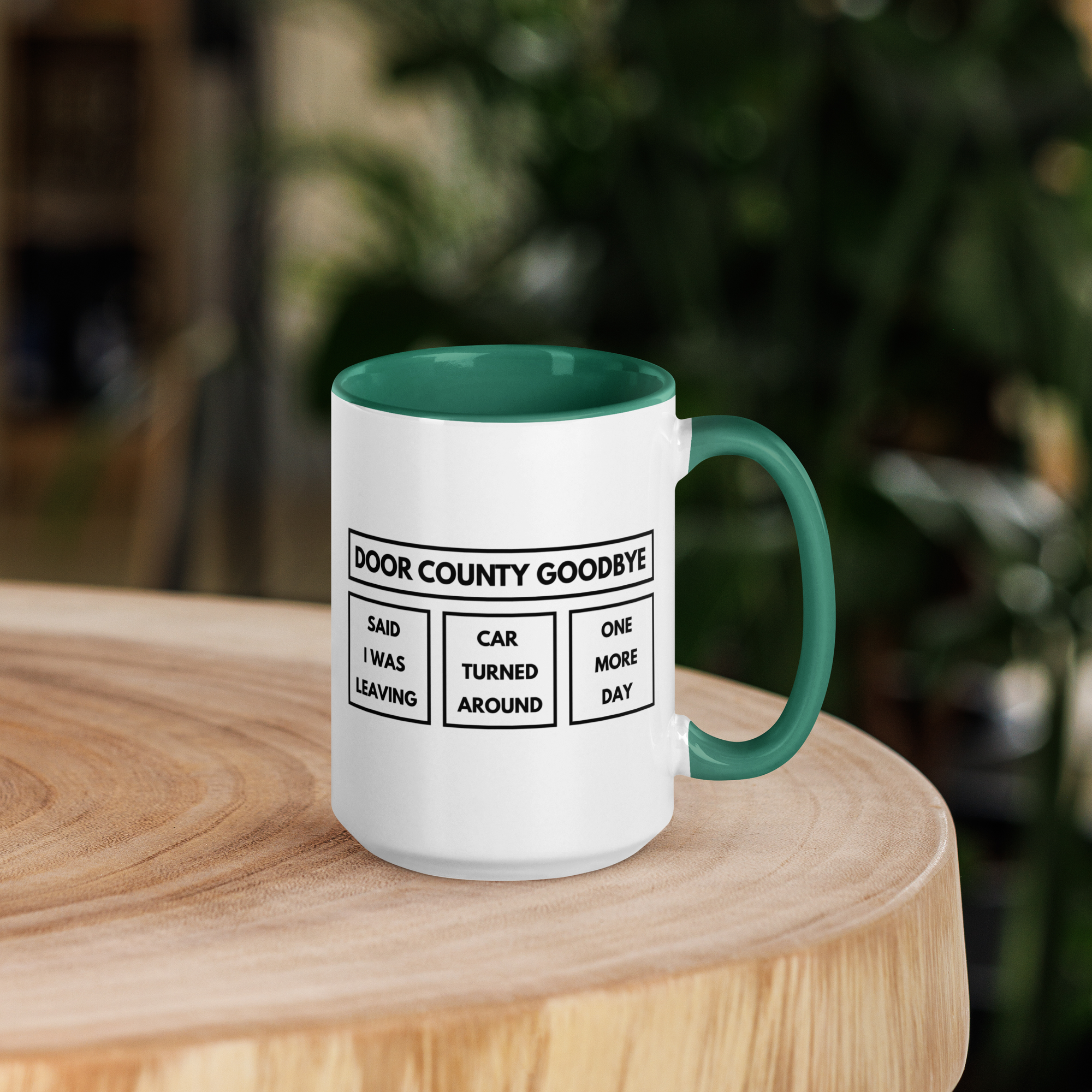 White mug with green interior and handle on a wooden surface with a blurred background